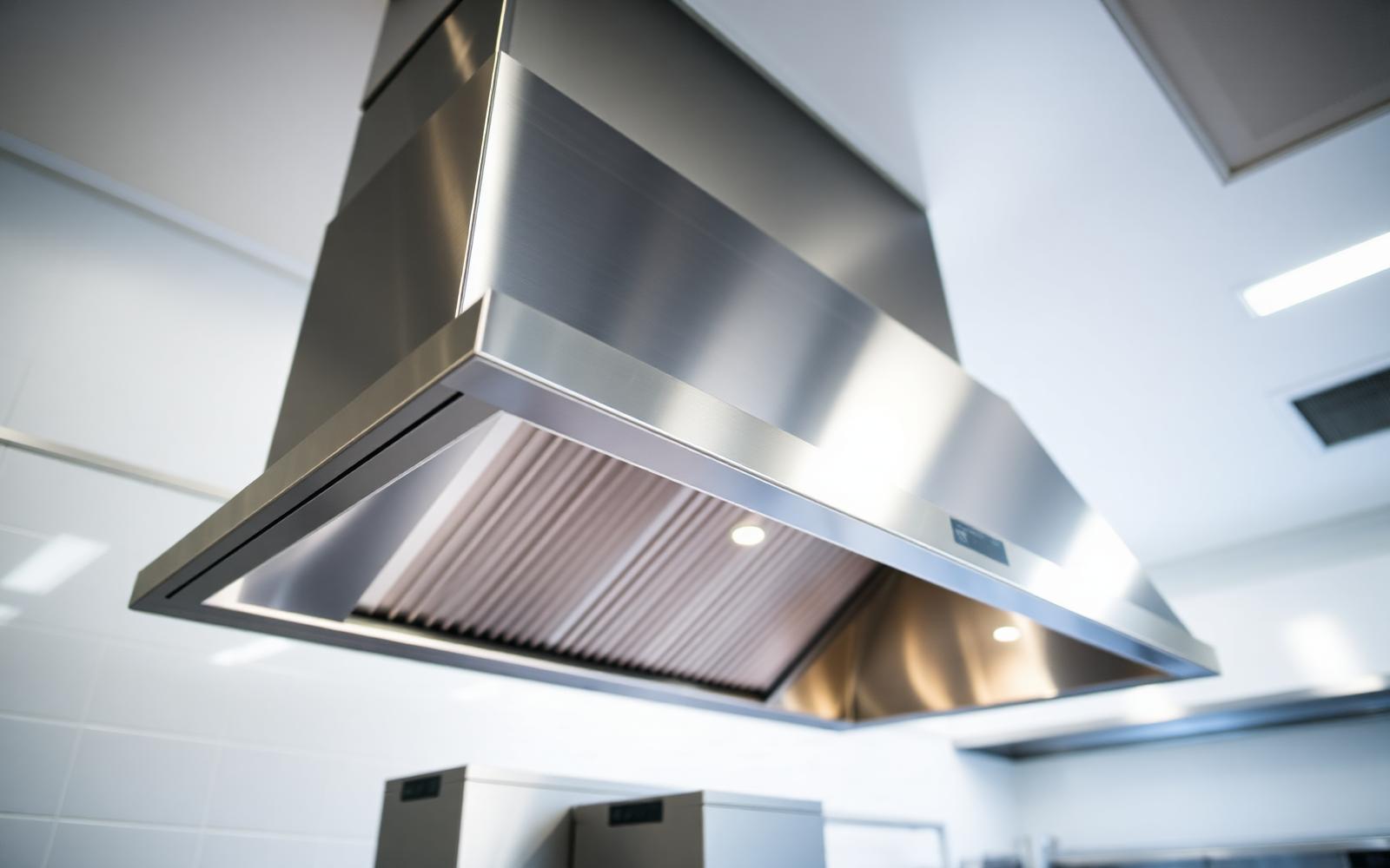 Roestvrijstalen afzuigkap in commerciële keuken, schoon en glanzend